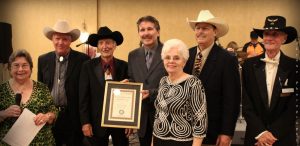 A.S.E. executive co-director Phyllis Cole (left) presents Bluegrass Band of the Year to Randall Franks (fourth from left) and the Georgia Mafia Bluegrass Band – from left, Pete Hatfield, Jerry Burke, Helen Burke, J. Max McKee, and Rick Smith. (Photo: JLynne Photography)